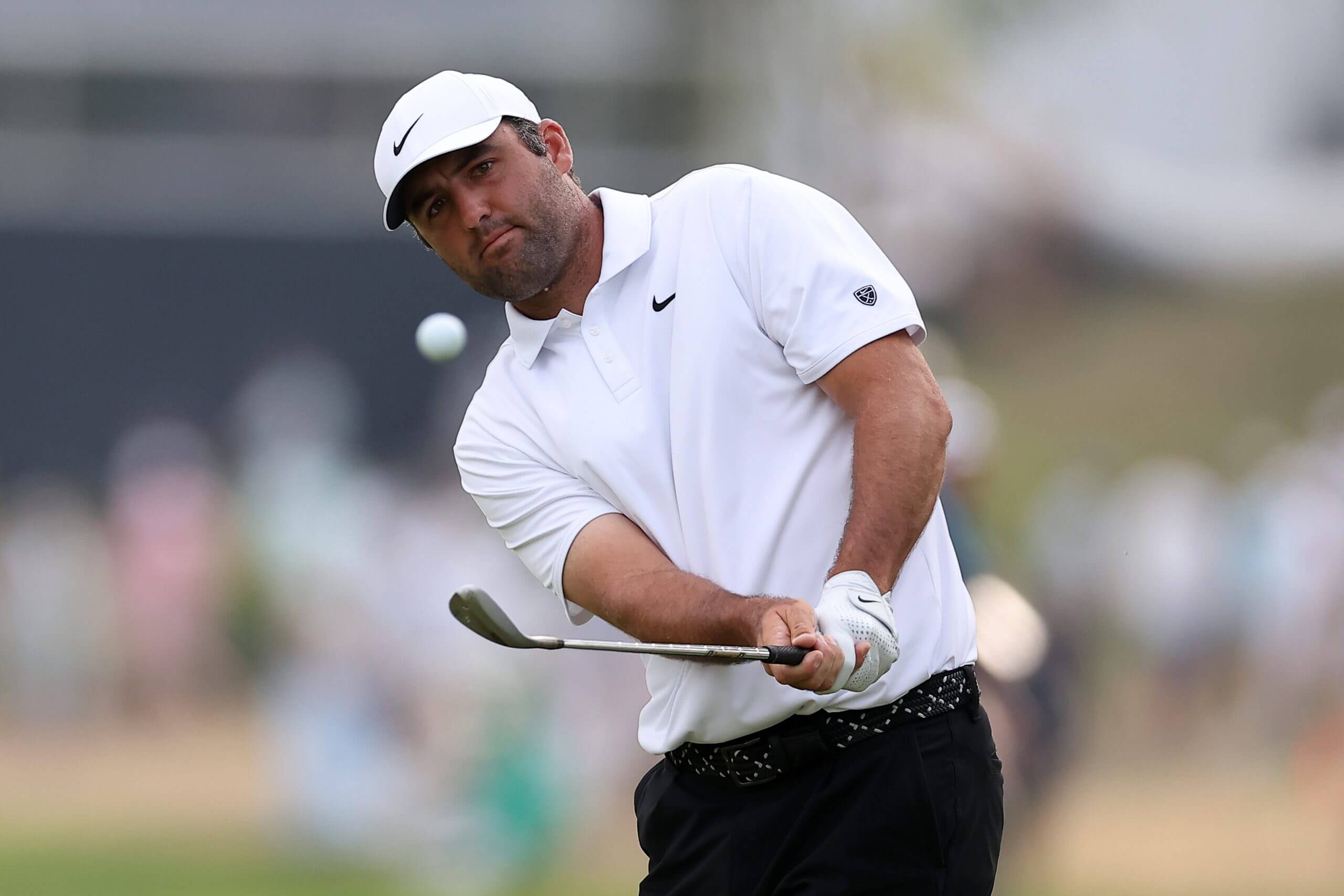 Scottie Scheffler hits onto the 18th green.