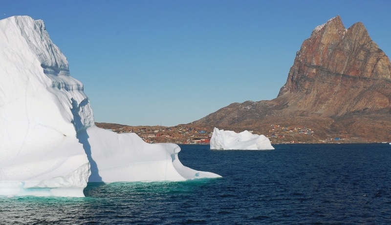 A white iceberg in dark blue water