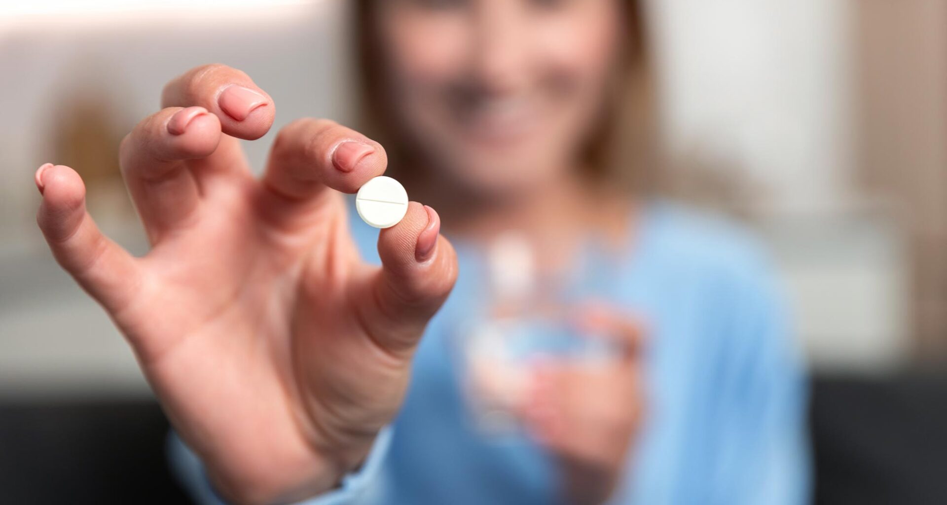 Young Woman Hand Holding White Pill Smiling
