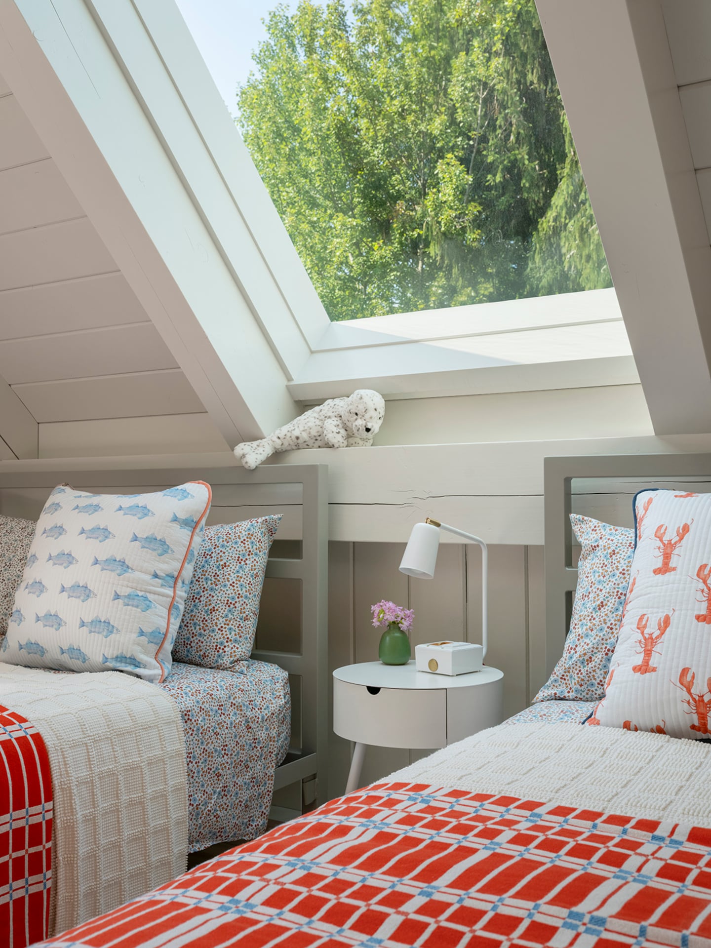 Beds in the upstairs guest room feature playful pillows from Maine artist Sara Fitz.