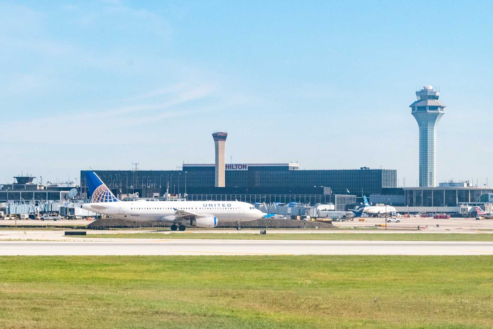 A United Airlines Airbus taxis in front of the Air Traffic Control tower and Airport Hilton hotel at ORD in Chicago.