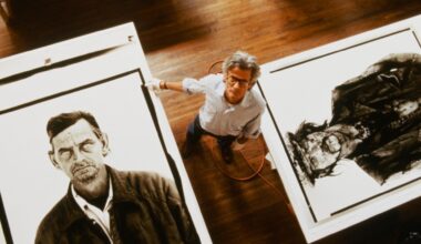 Shot from above, Avedon stands on a wooden studio floor between two enormous exhibition prints from his In the American West series, dwarfed by the faces around him.