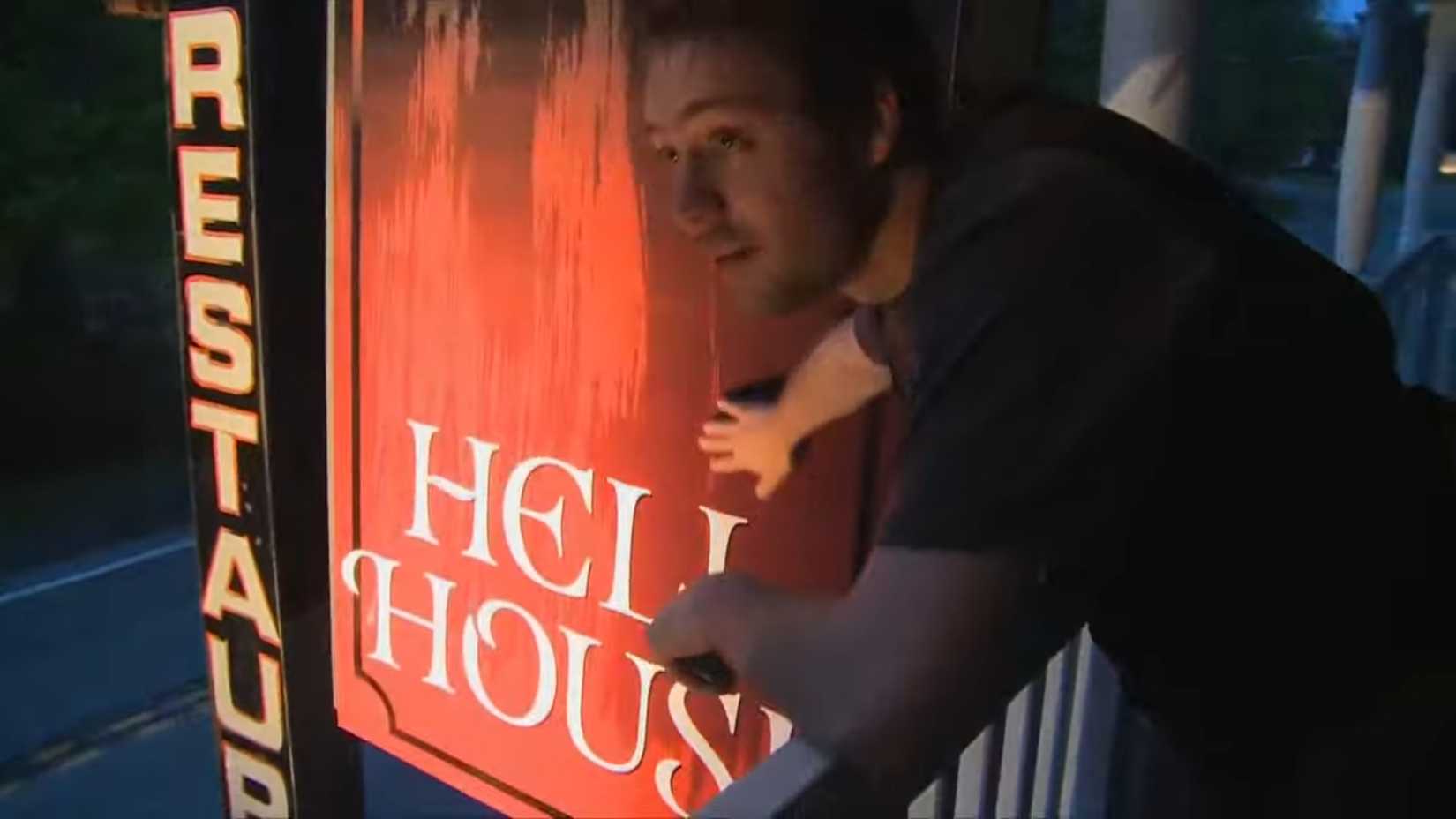 Alex putting up the Hell House sign on the Abaddon Hotel in Hell House LLC