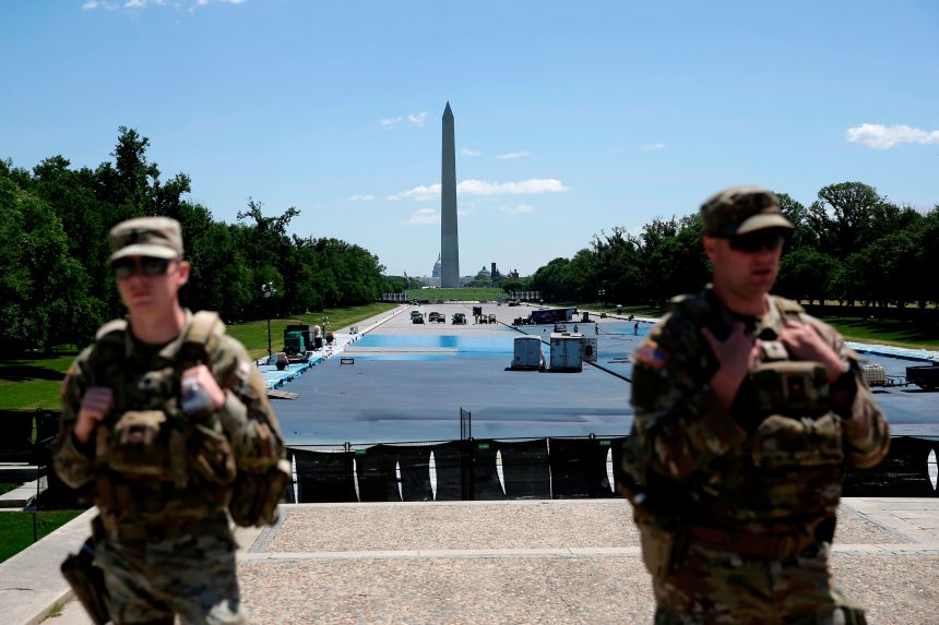 As National Guard solider patrol, workers continue to apply a blue protective coating as part of a renovation project to the Lincoln Memorial Reflecting Pool, Friday, May 8, 2026, on the National Mall in Washington.