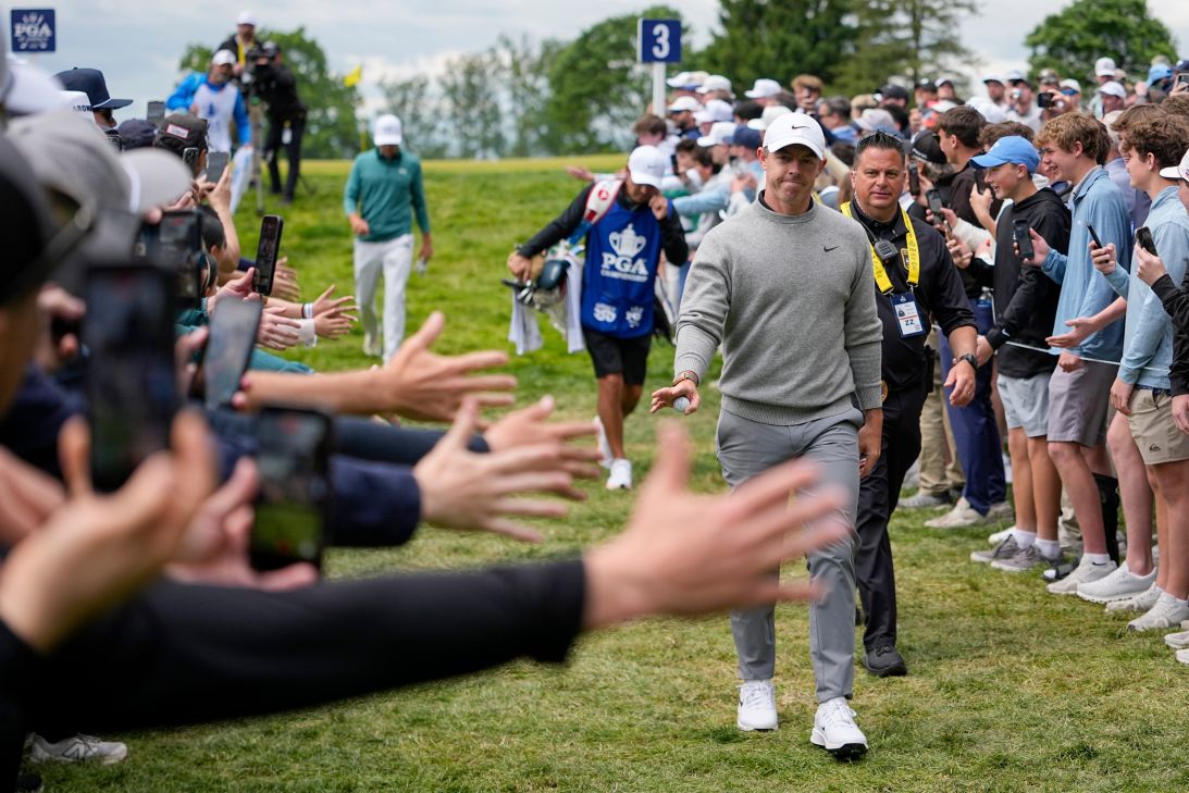 Fans reach towards Rory McIlroy, of Northern Ireland, as he walks to the fourth tee during the second round of the PGA Championship golf tournament at Aronimink Golf Club, Friday, May 15, 2026, in Newtown Square, PA. (AP Photo/Frank Franklin II)