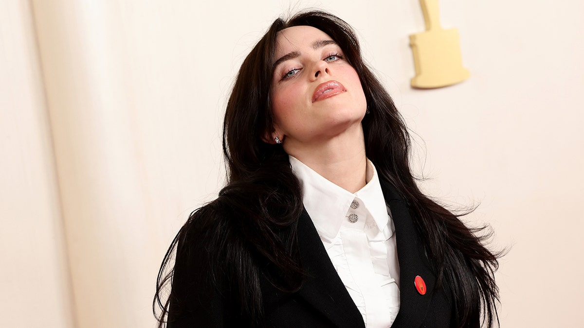 Billie Eilish wearing a black suit and pro-Gaza pin at the Academy Awards carpet
