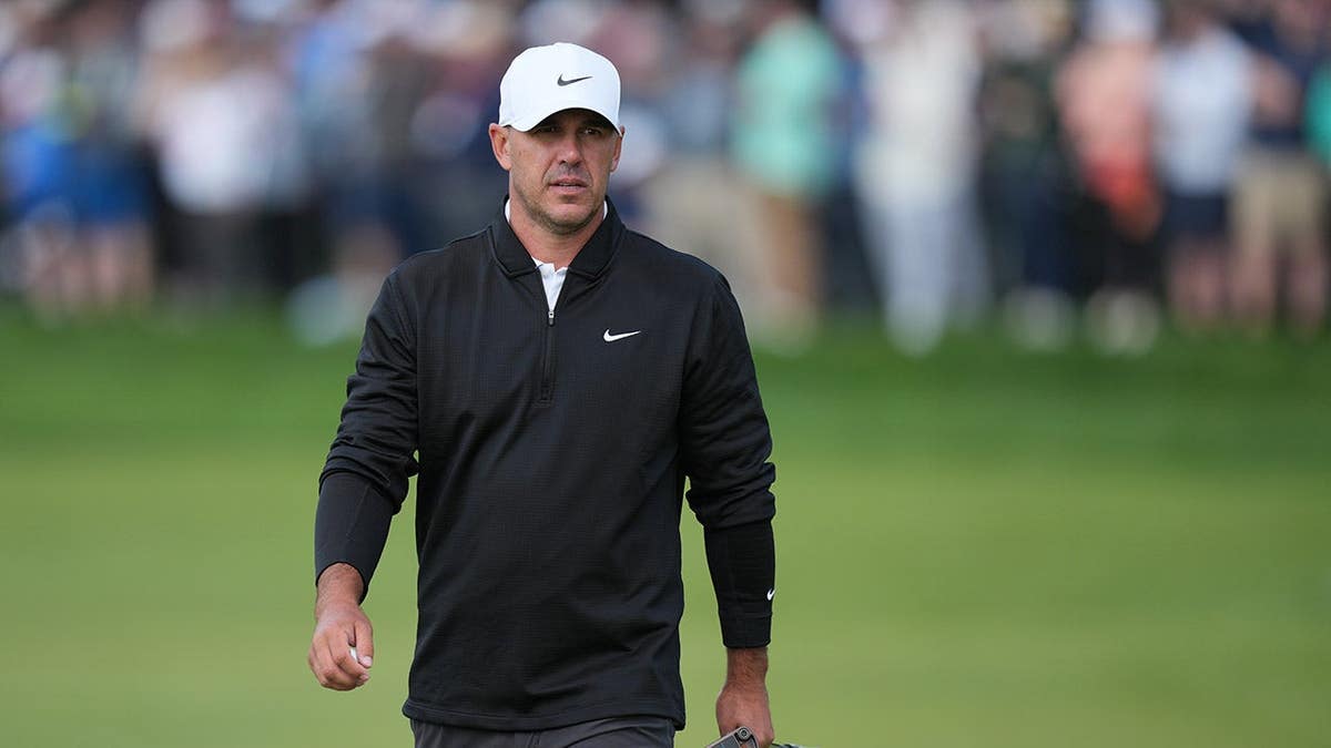 Brooks Koepka walking on the 18th green at Aronimink Golf Club