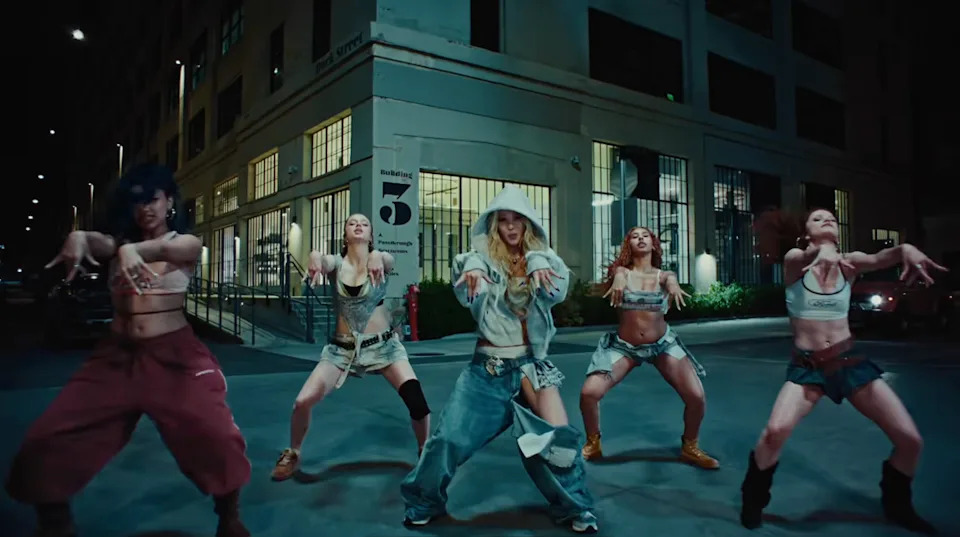 Five women in casual outfits including shiloh jolie dance in a city street at night in a video by Dayoung