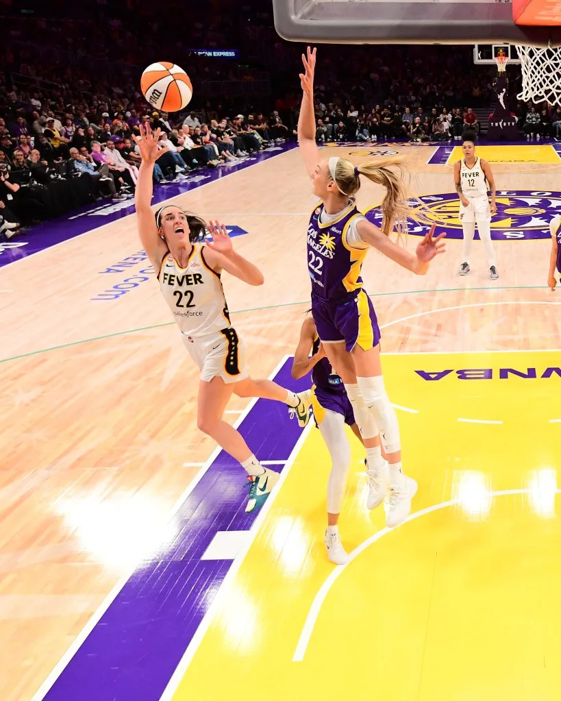 Sparks forward Cameron Brink, top, blocks a shot by Fever guard Caitlin Clark during the first half of a WNBA game, May 13, 2026, in Los Angeles. NBAE via Getty Images