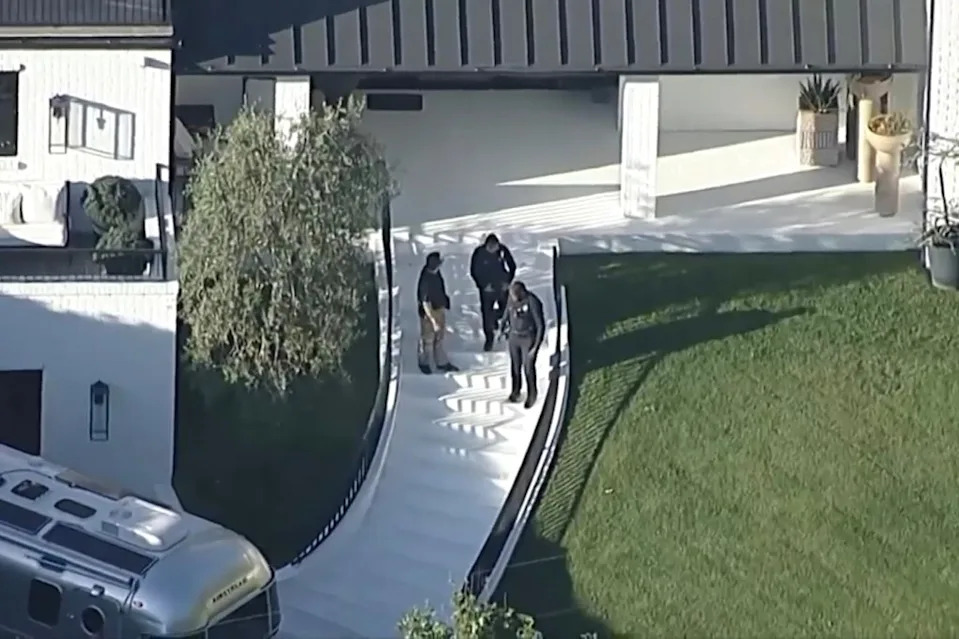 Police swarm Rihanna’s mansion after the shooting. AP