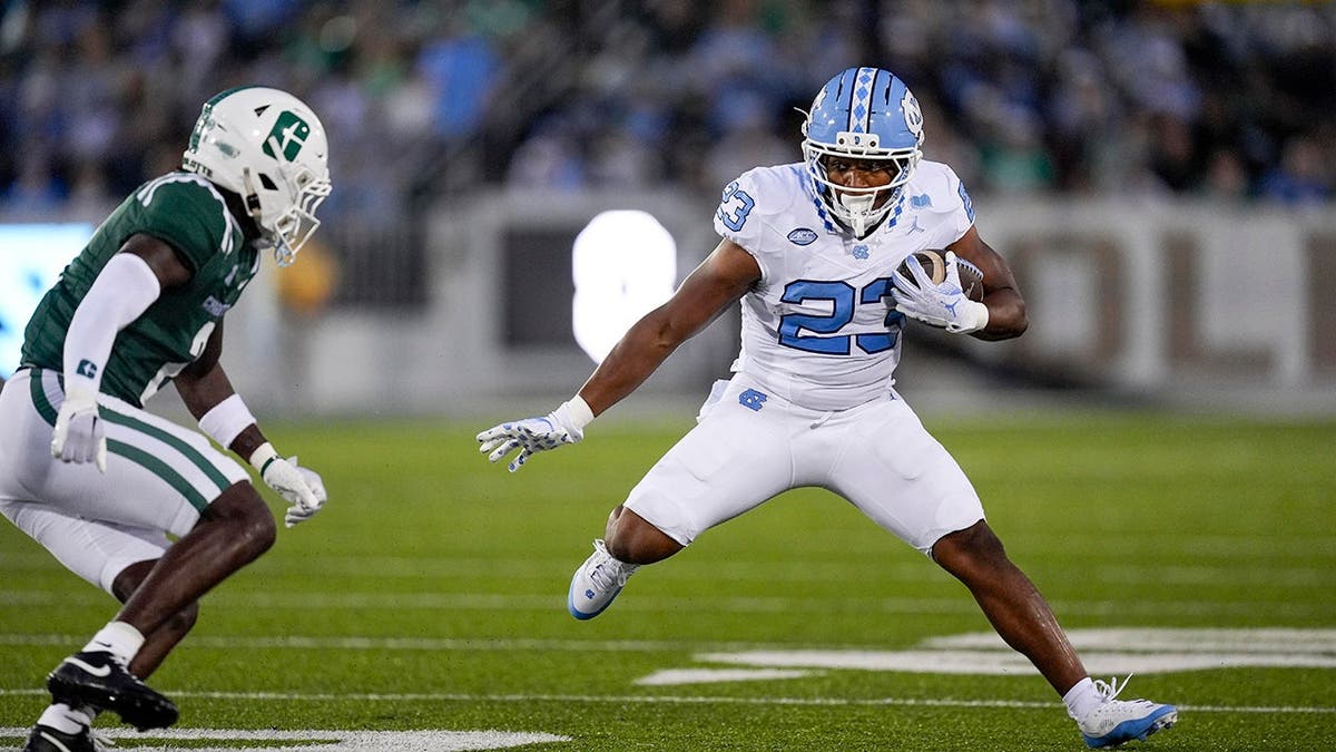 North Carolina Tar Heels running back Charleston French running with the ball defended by Charlotte 49ers defensive back Treyveon McGee