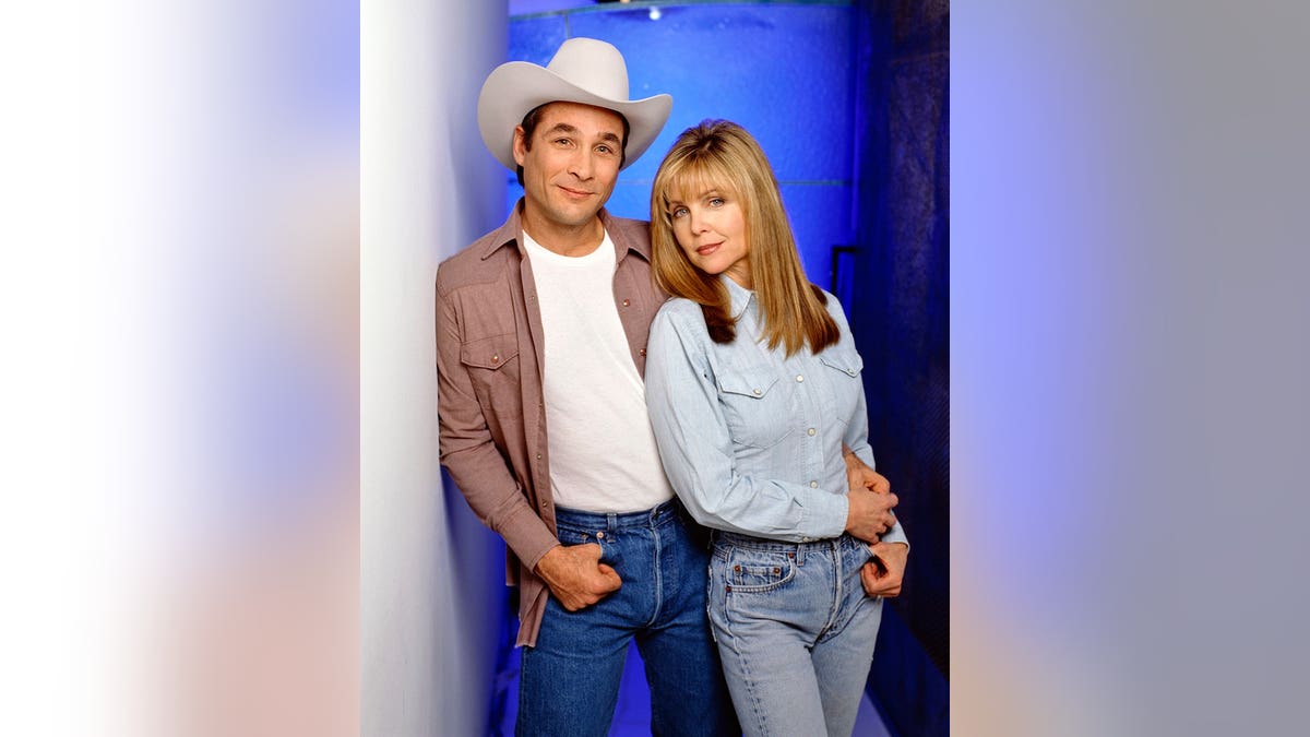 Clint Black and Lisa Hartman standing together in a scene from Cadillac Jack movie