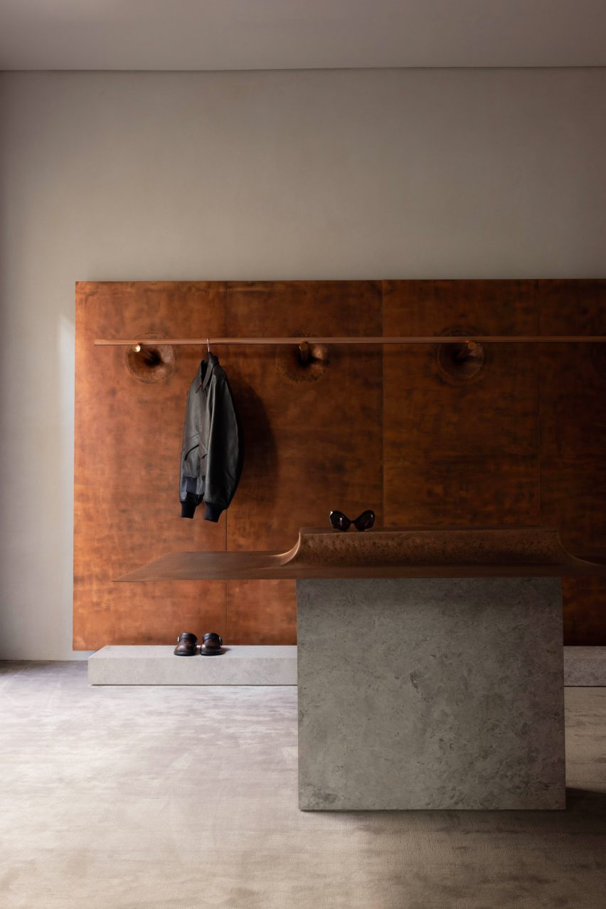 Copper display elements against lime-plaster walls and a bamboo silk carpet