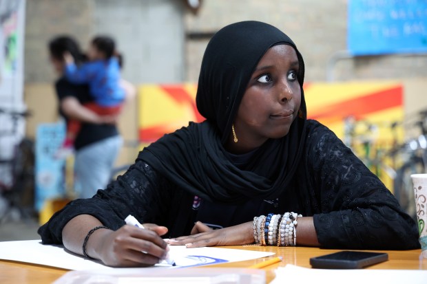 At Communities United, Muna Abdullahi makes a sign on May 12, 2026, to be used at an upcoming mental health summit for young people. (Terrence Antonio James/Chicago Tribune)