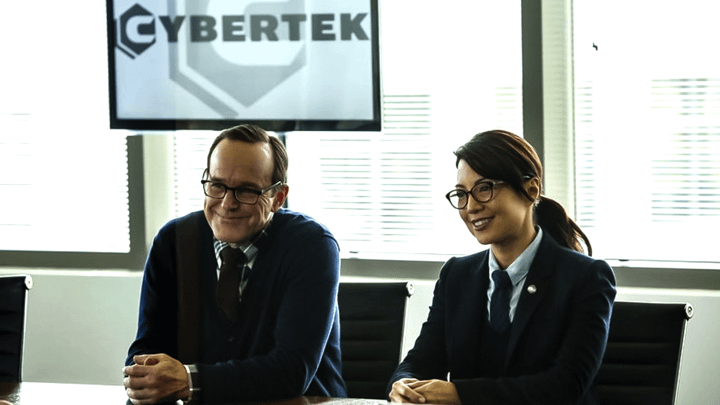 Clark Gregg's Phil Coulson and Ming-Na Wen's Melinda May in front of a Cybertek sign.