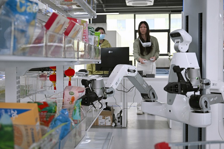 A researcher trains a humanoid robot in a lab.