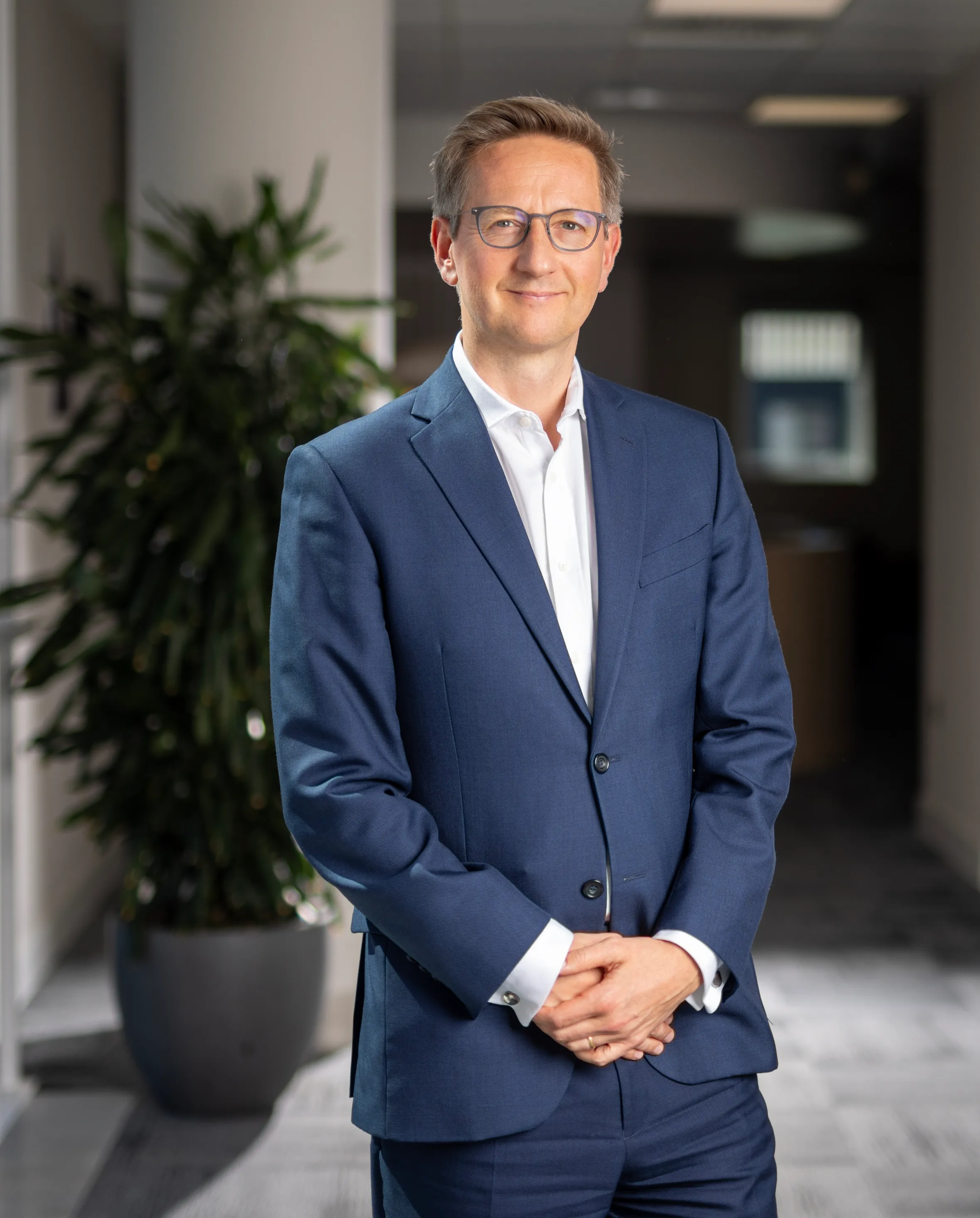 Oliver Holbourn, CEO of the National Wealth Fund, posing in an office.