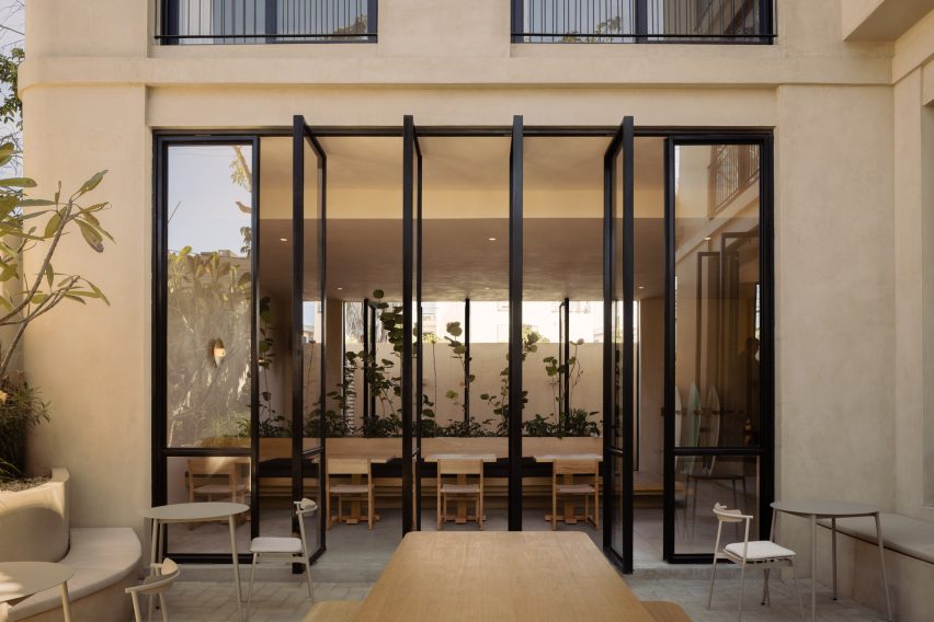 Glass panels pivot open from a cafe interior to the outside