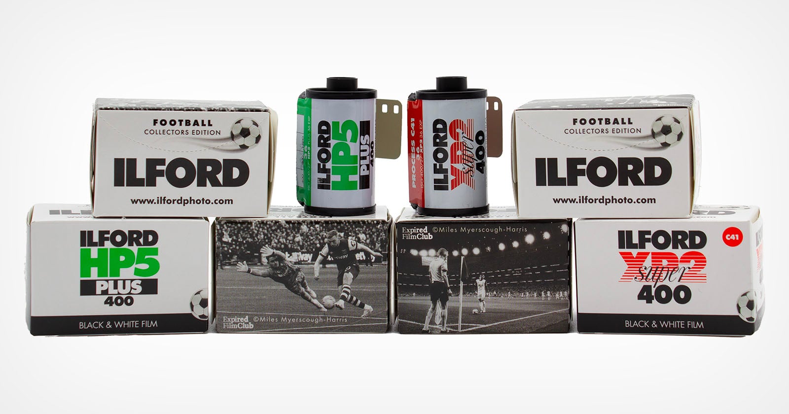 Six boxes and two rolls of Ilford black and white film, labeled as football collectors edition, are arranged in two rows. The boxes feature vintage football match photos and different Ilford film types.