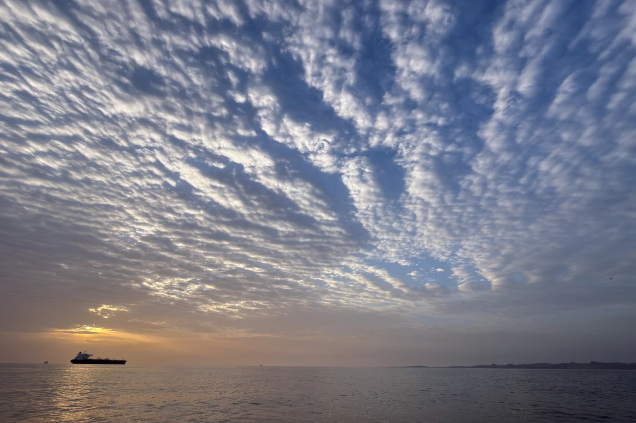 The sun rises behind a tanker anchored in the Strait of Hormuz off the coast of Qeshm Island, Iran, on April 18.