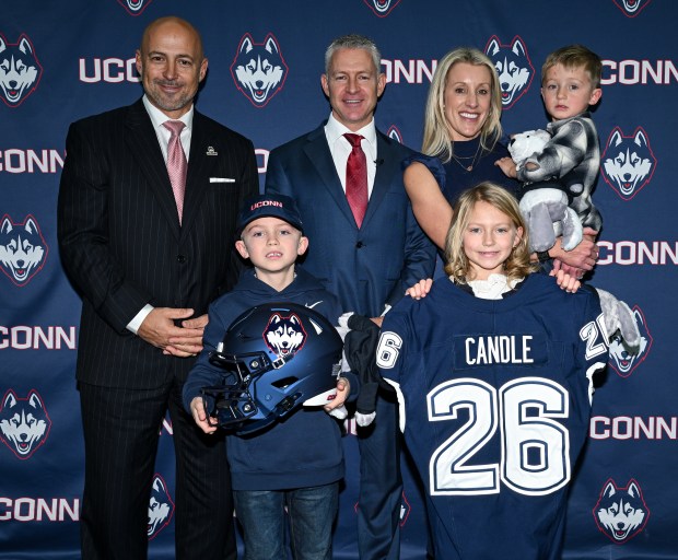 UConn Athletic Director David Benedict, left, poses with his new football coach, Jason Candle, center, Candle's wife, Nicole, and their children during his introductory press conference on Monday. (Courtesy of UConn)