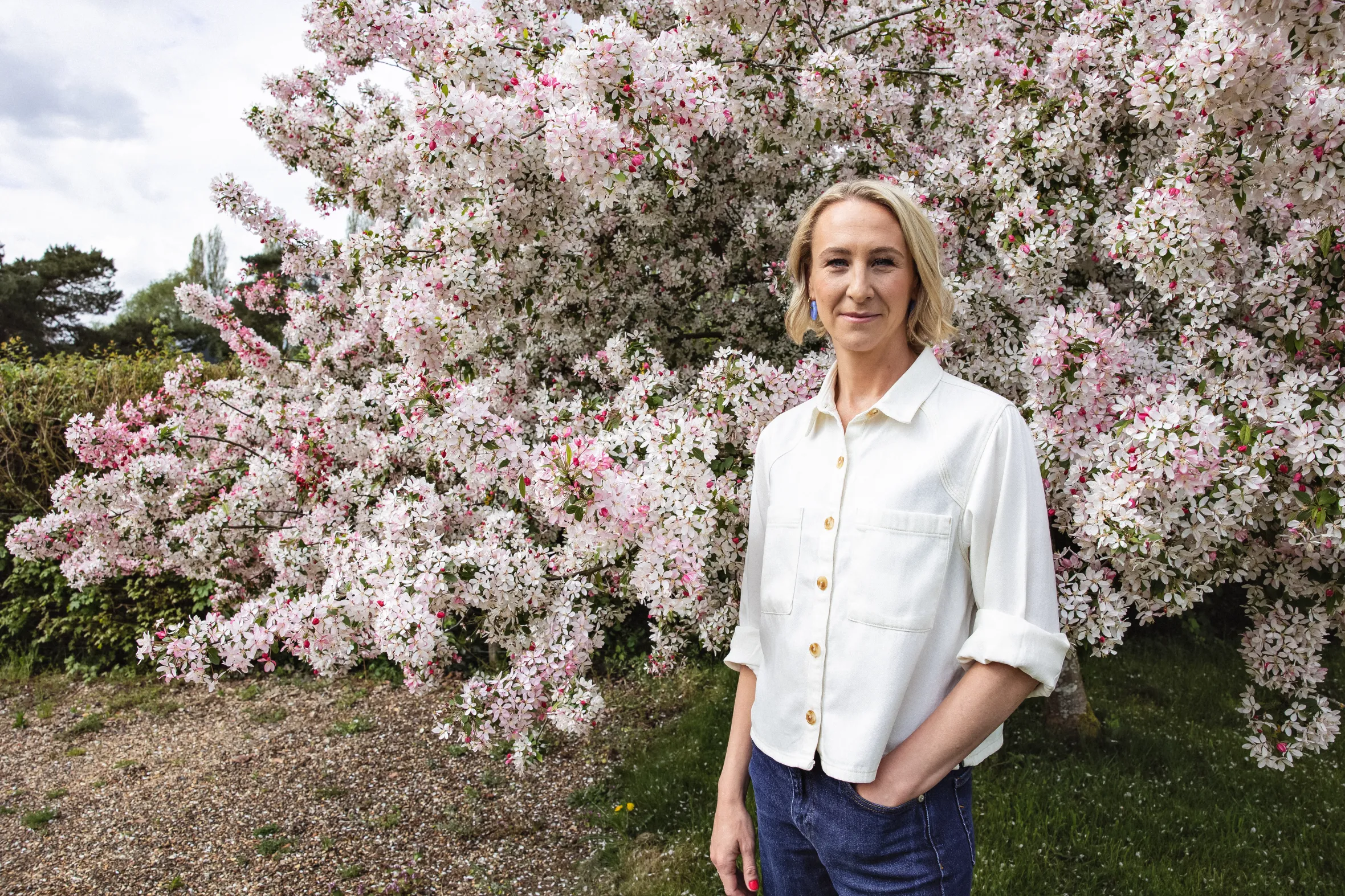 India Sturgis standing in front of a blooming tree.