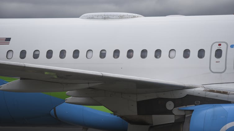 the body of a jetliner with the blinds down on some windows
