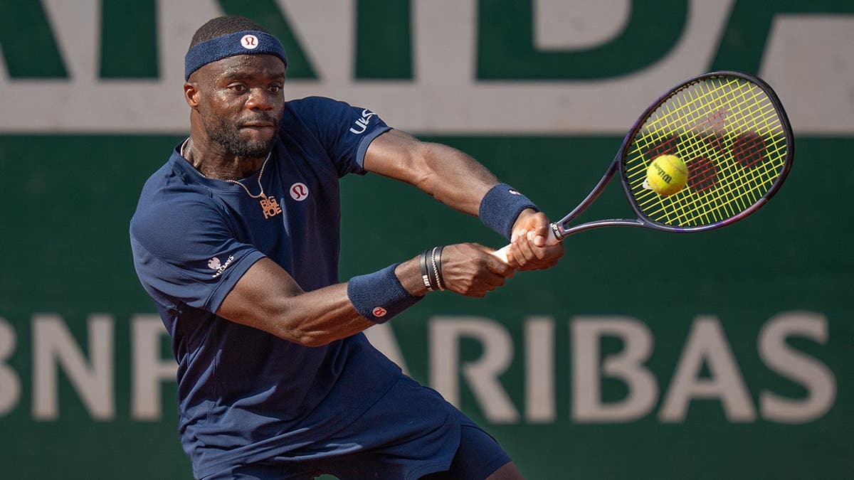 Frances Tiafoe returning a shot during a tennis match at Stade Roland Garros