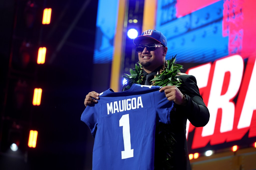 Francis Mauigoa of Miami holds up a New York Giants jersey after being selected in the 2026 NFL Draft.
