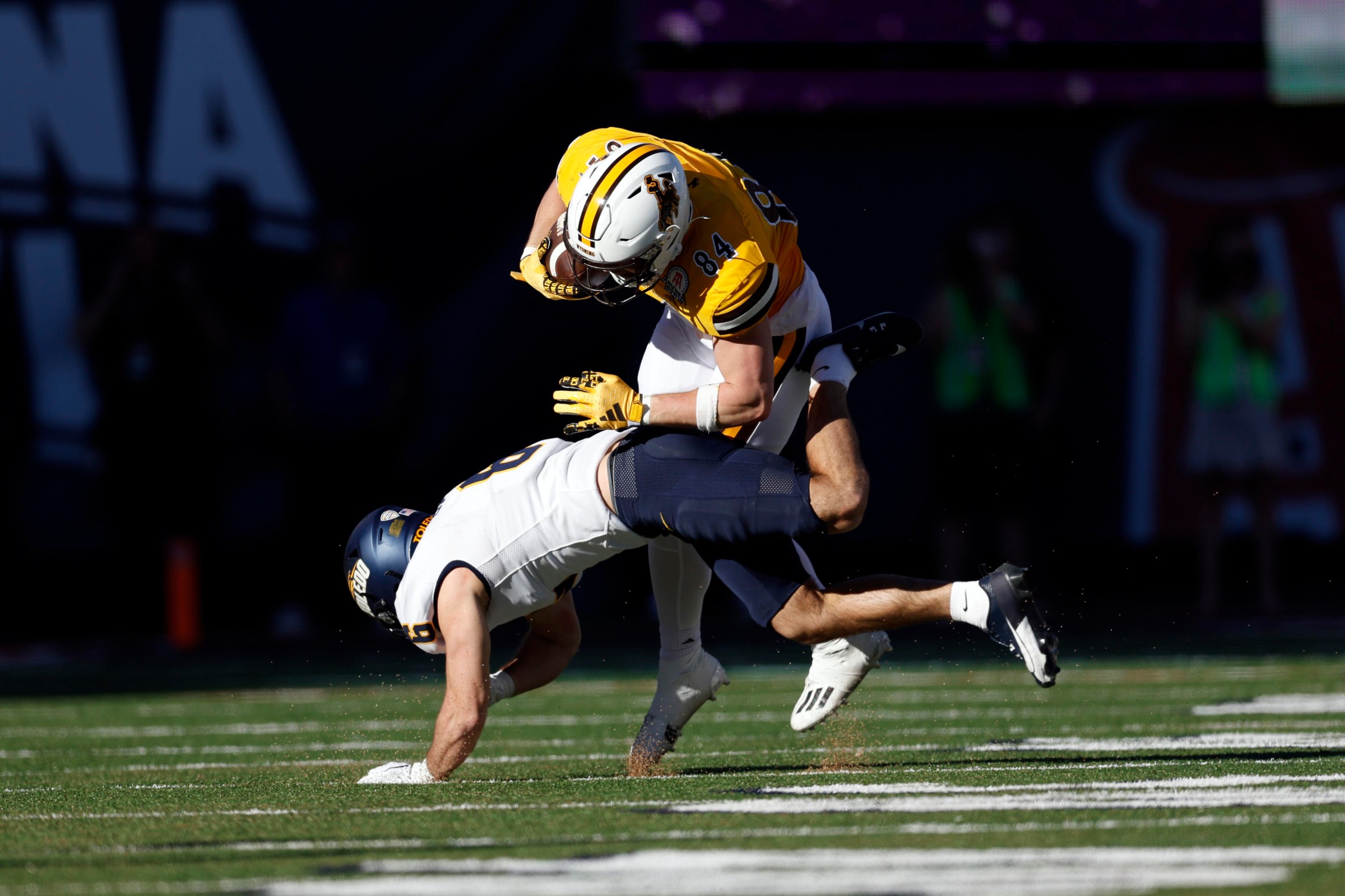 TUCSON, ARIZONA - DECEMBER 30: Safety Nate Bauer #6 of the Toledo Rockets tackles tight end John Michael Gyllenborg #84 of the Wyoming Cowboys during the Barstool Sports Arizona Bowl at Arizona Stadium on December 30, 2023 in Tucson, Arizona. The Cowboys defeated the Rockets 16-15. (Photo by Chris Coduto/Getty Images)