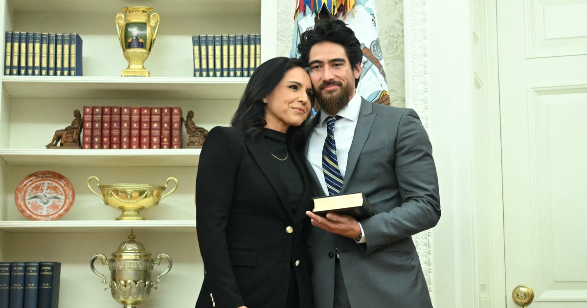 Tulsi Gabbard and her husband Abraham Williams hug before she is sworn in as director of national intelligence in the Oval Office on Feb. 12, 2025.