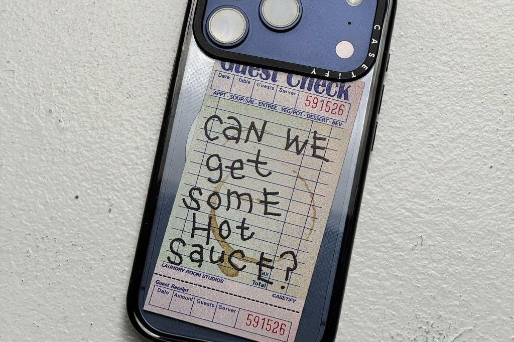 A phone with a transparent case and a receipt inside it that says "CAN WE get SOME Hot Sauce?".