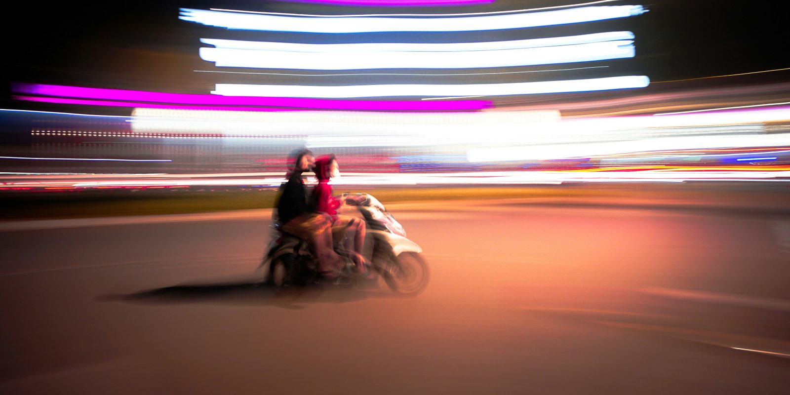 iPhone thieves can get up to $800 more if they snatch unlocked devices | Blurred photograph of two people riding a scooter