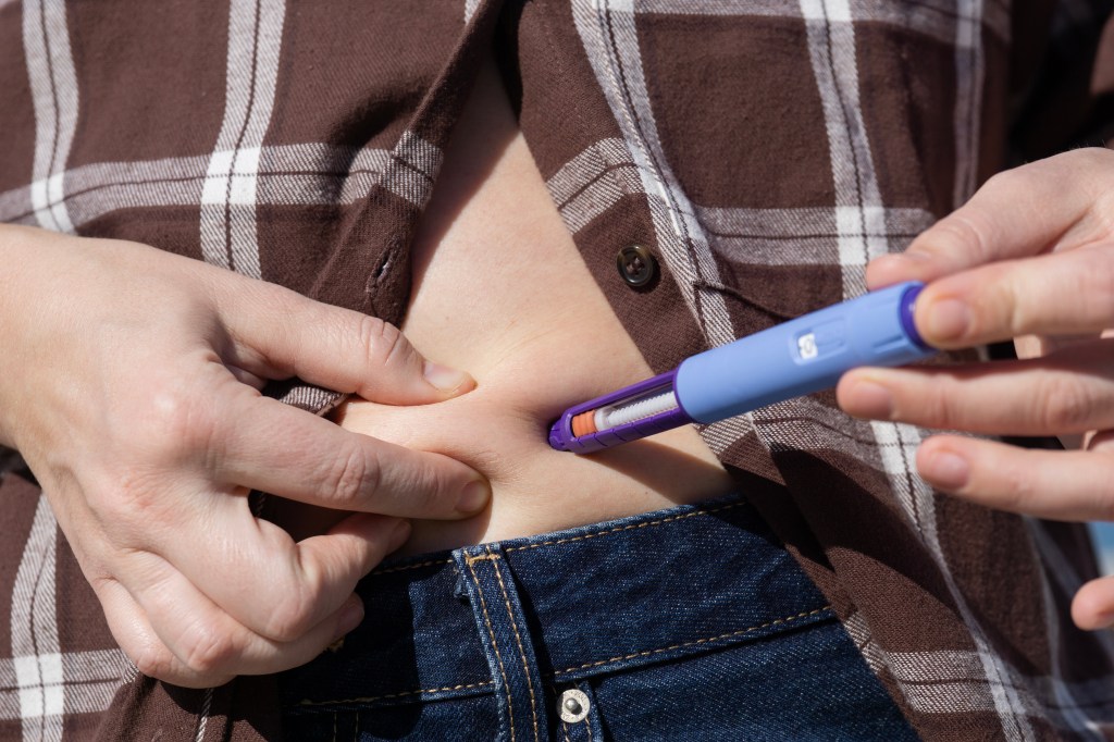 A person injecting Ozempic into their stomach