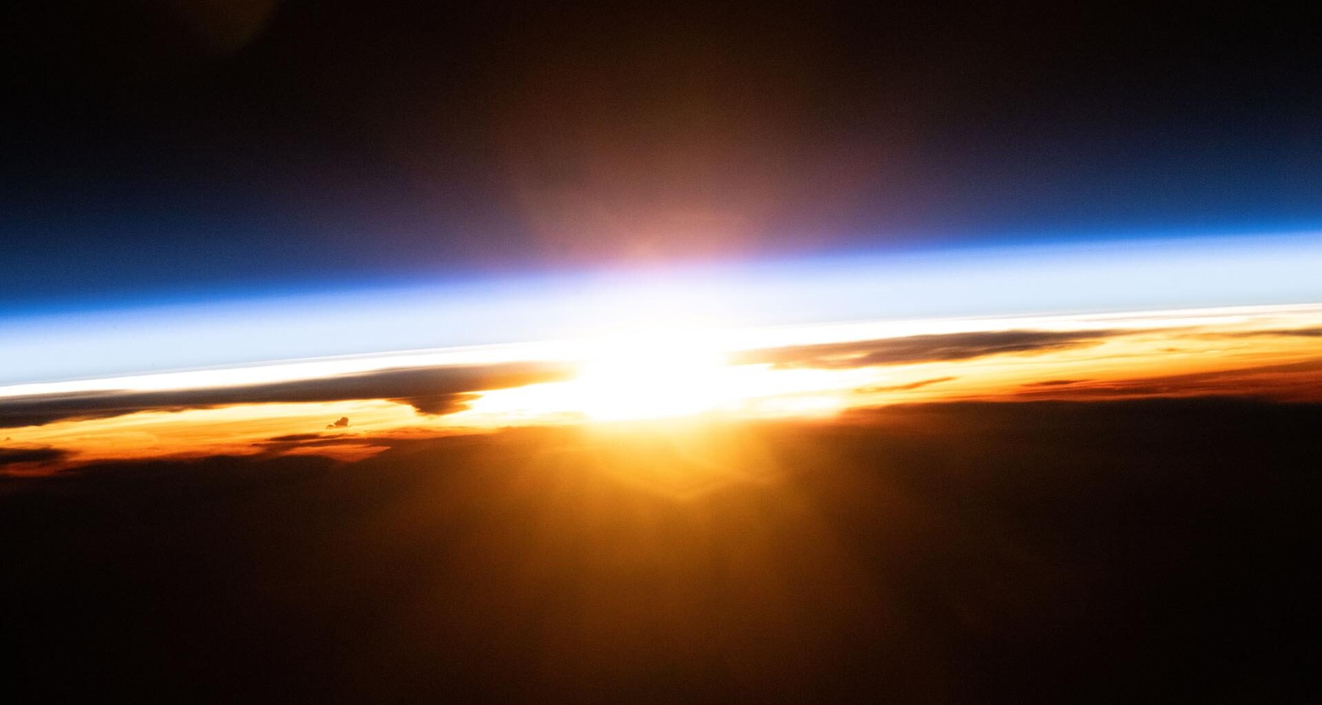 The last rays of an orbital sunset illuminate Earth's atmosphere and the cloud tops in this photograph from the International Space Station as it orbited 258 miles above the Pacific Ocean north of Papua New Guinea.