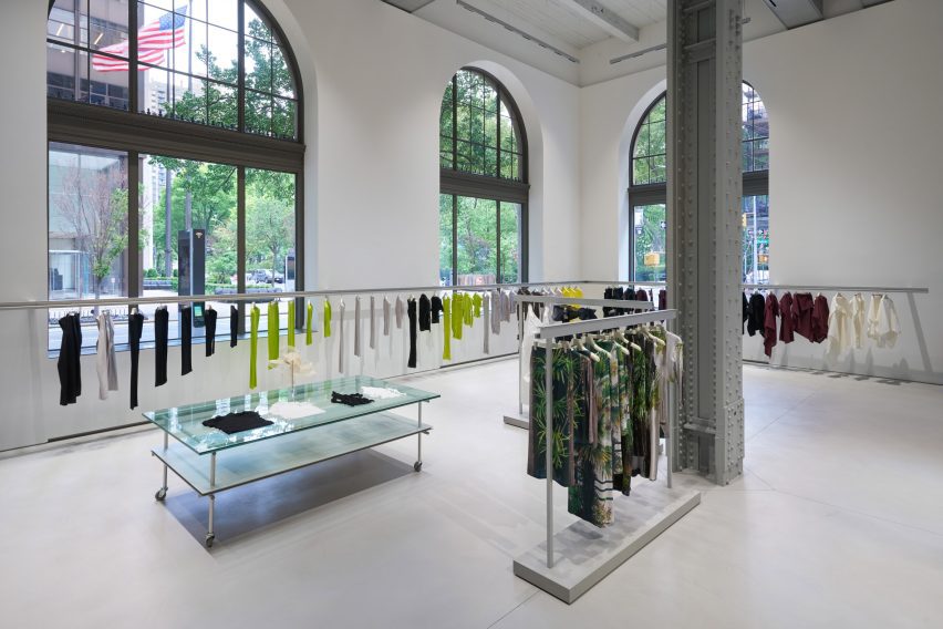 A continuous garment rail spans across grand arched windows