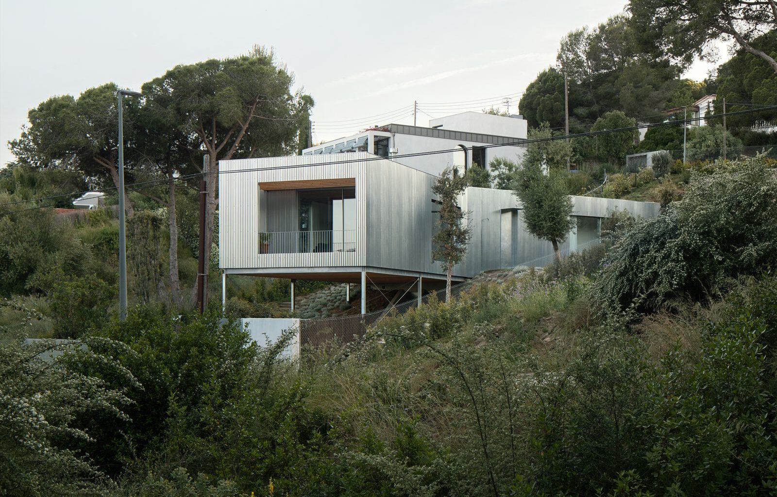 Wood Prefab Panels Cloaked in Galvanized Steel Form a Hillside Home in Barcelona