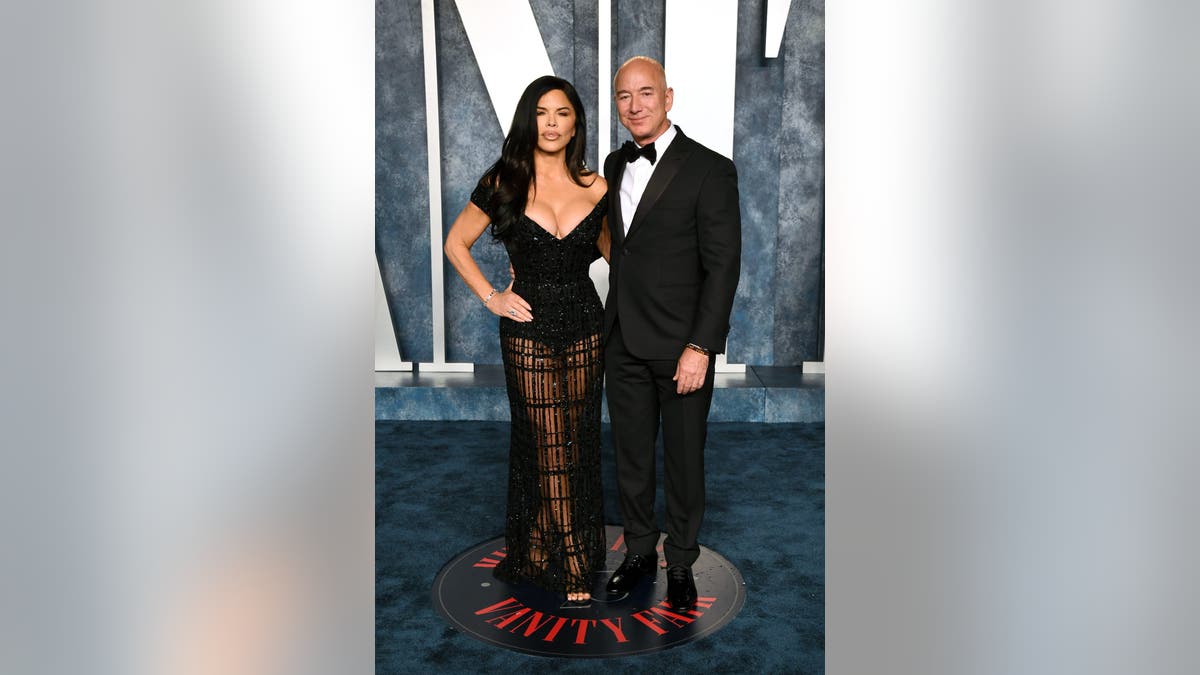 Lauren Sanchez and Jeff Bezos standing together at an event venue.