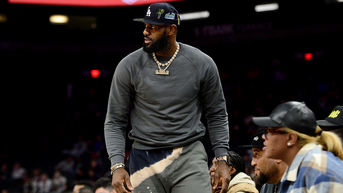 LeBron James standing courtside at a Sierra Canyon basketball game.