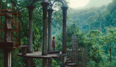 a white woman with dark curly hair standing in a beautiful architectural structure in a forest