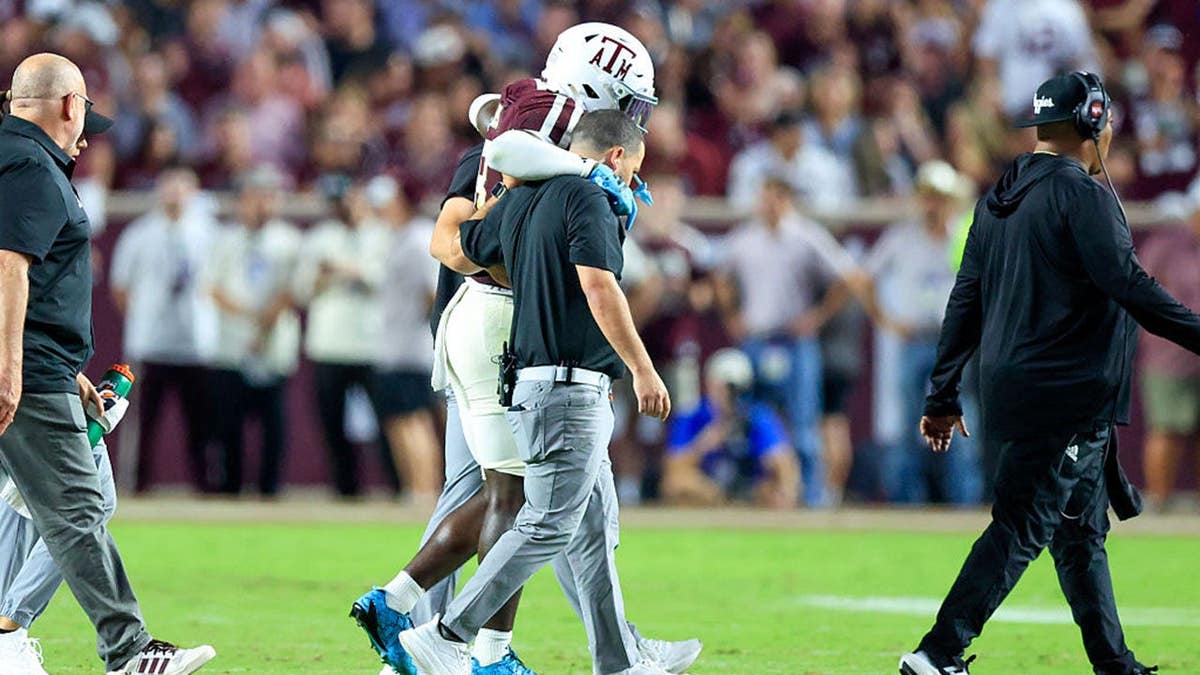 Texas A&M running back Le'Veon Moss being helped off the field at Kyle Stadium.