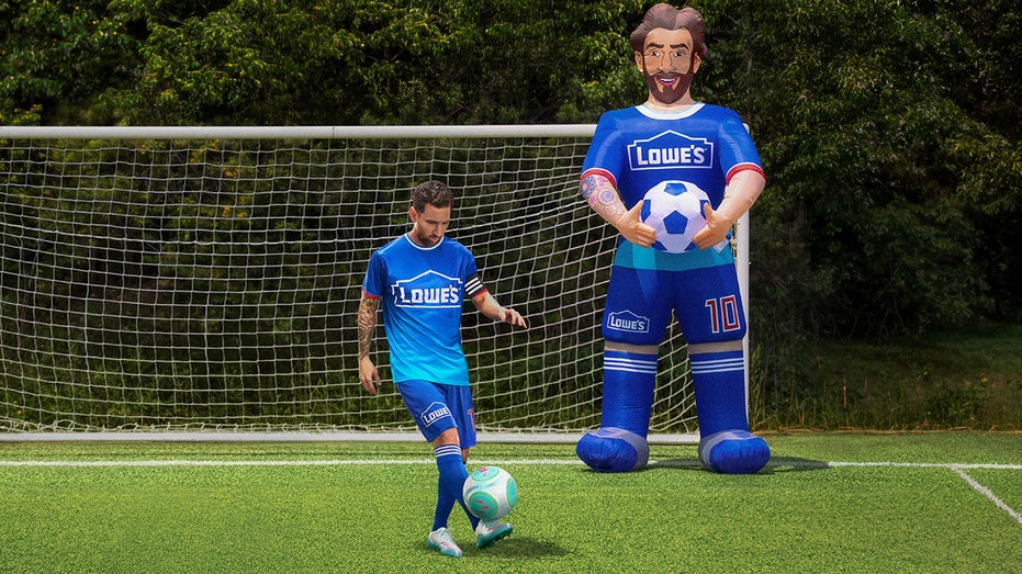 Lionel Messi kicks soccer ball in front of 10-foot inflatable