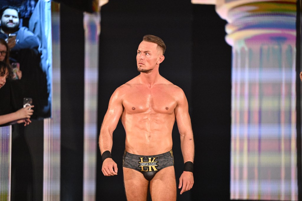 Ludwig Kaiser making his way to the ring in black trunks with "LV European Elegance LK" written on them.