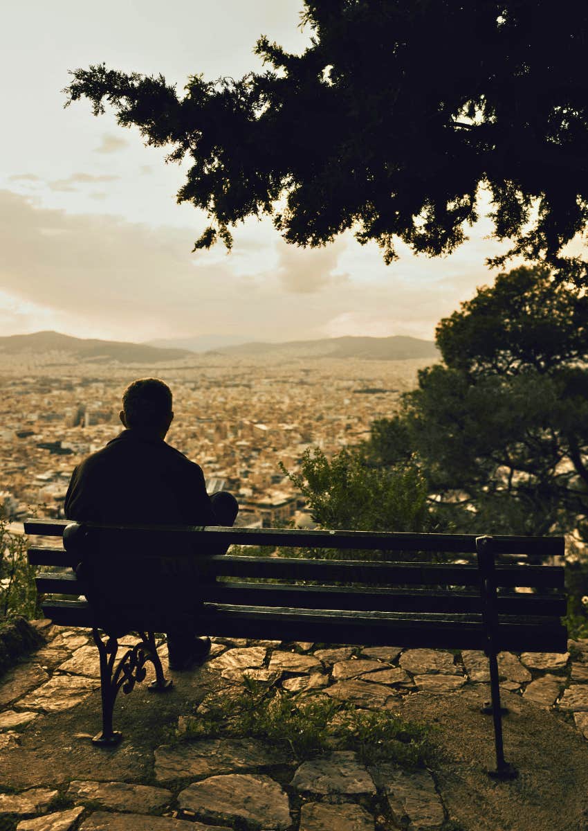 heartbroken man sitting alone at lookpoint