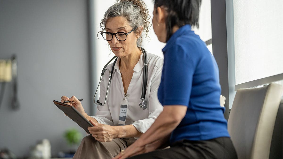 Medical practitioner discussing healthcare concerns with a patient in a clinic