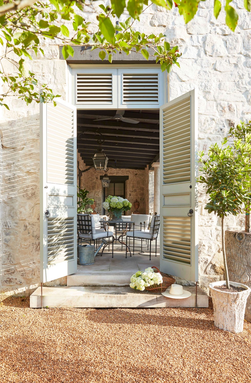 louvred doors to an expansive loggia are
painted pigeon by farrow and ball