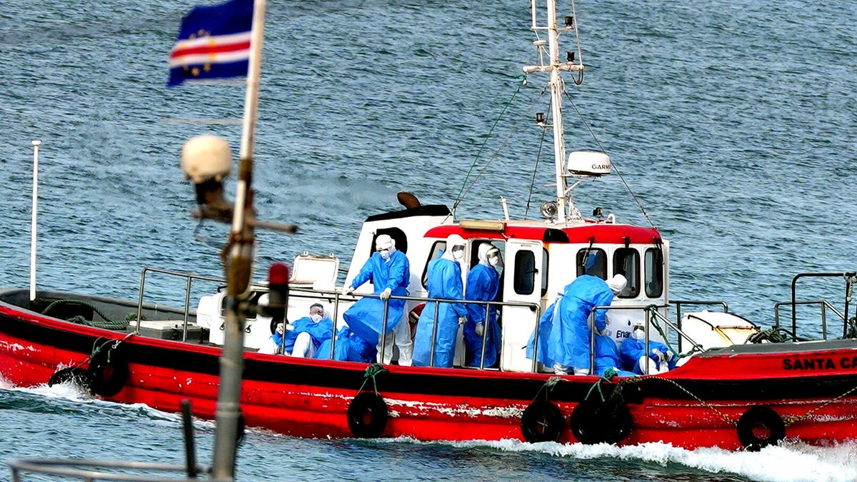 Health workers in protective gear evacuating patients from MV Hondius cruise ship at port