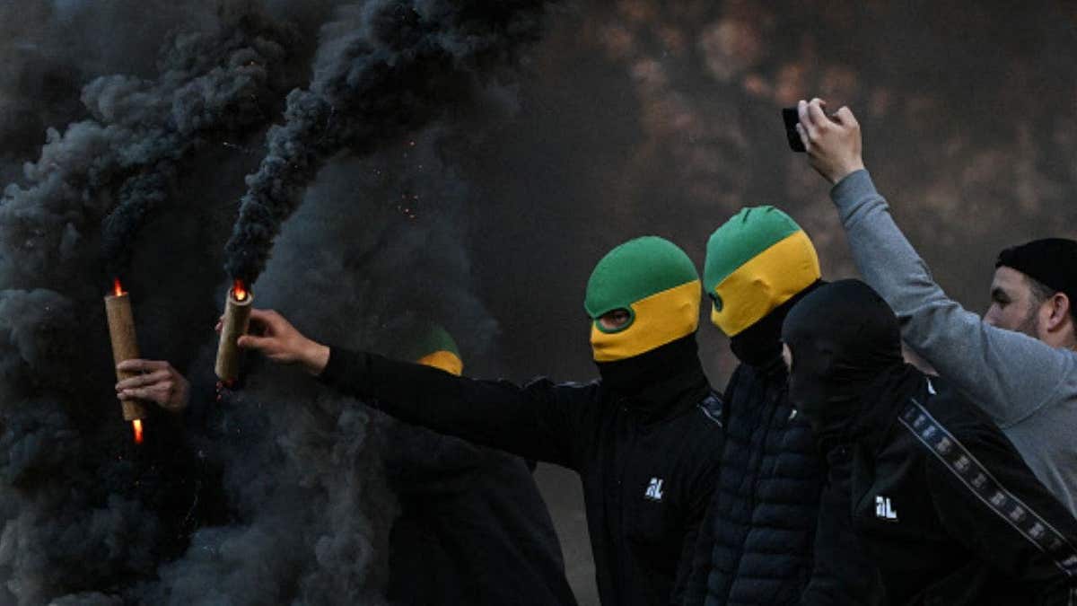 TOPSHOT - Nantes' supporters holding smoke flares attempt to invade the pitch during the French L1 football match between FC Nantes and Toulouse FC at the Stade de la BeaujoireLouis Fonteneau in Nantes, western France, on May 17, 2026. (Photo by Sebastien Salom-Gomis / AFP via Getty Images)