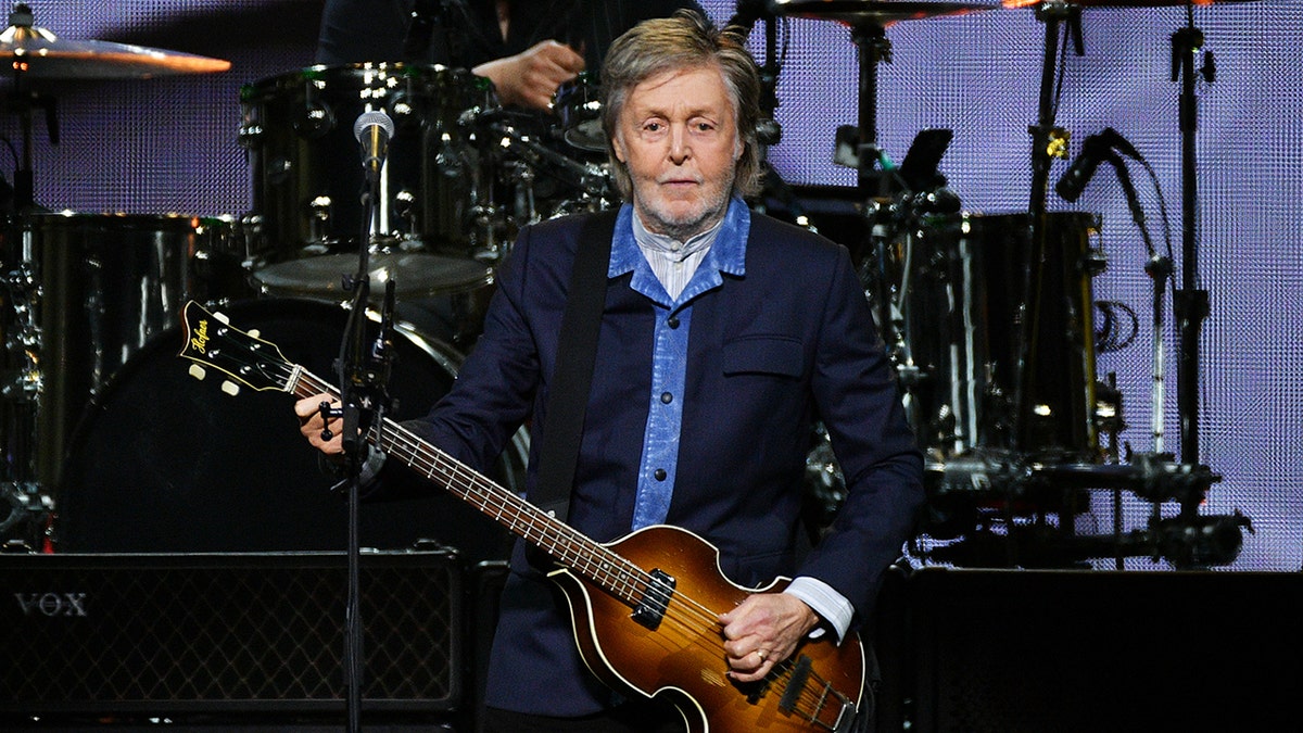Sir Paul McCartney playing guitar on stage at The O2 Arena in London