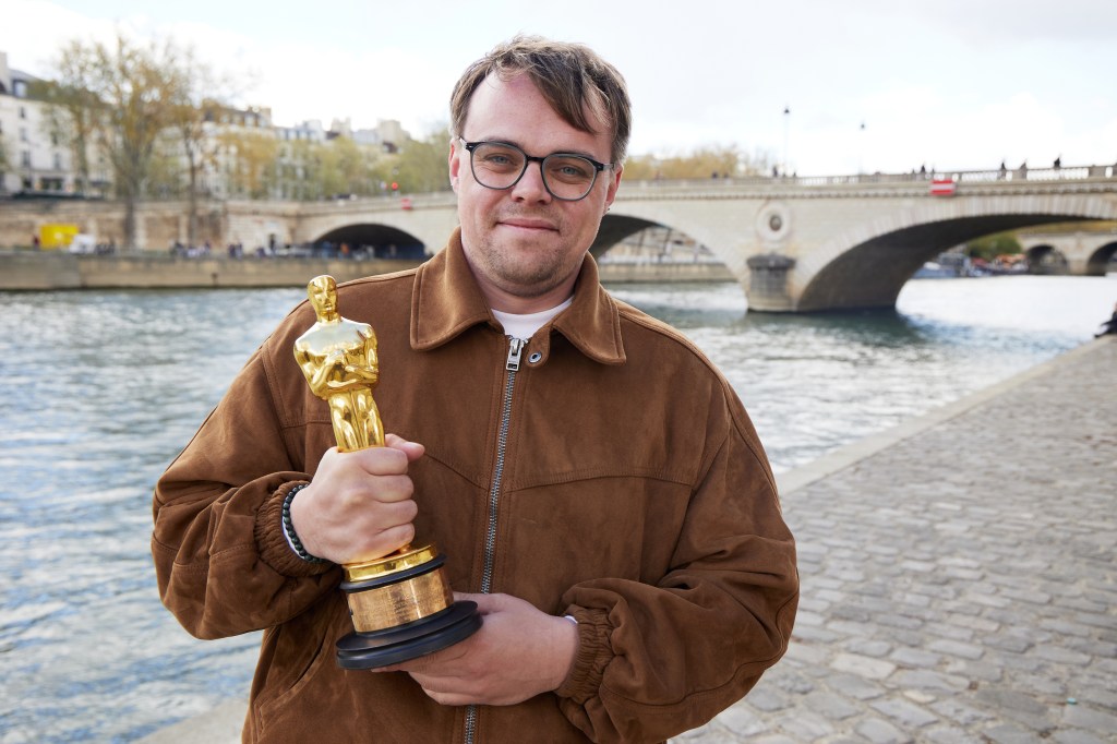 Pavel Talankin poses with his Oscar statuette by the Seine River in Paris.
